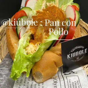 a sandwich in a basket with lettuce and tomato