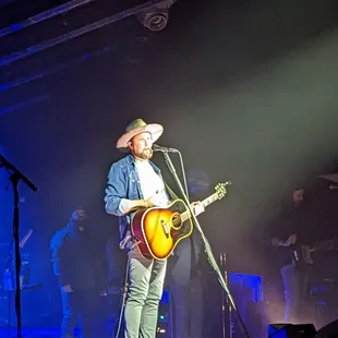 a man in a cowboy hat playing a guitar