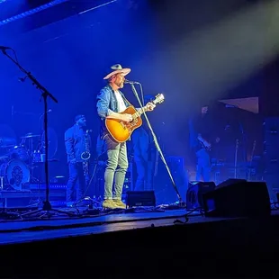 a man in a cowboy hat playing a guitar
