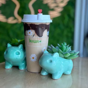 a cup of coffee with a lid and a planter