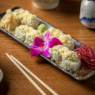 a plate of sushi and chopsticks