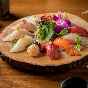 a variety of sushi on a wooden plate