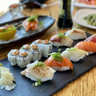 a variety of sushi on a slate platter