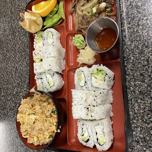 a tray of sushi and a bowl of rice