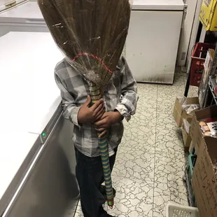 a boy with a broom on his head