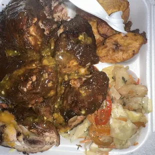 Jerk chicken combo over red beans and rice with seasoned cabbage and plantains