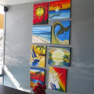 a table with a vase of flowers and paintings on the wall