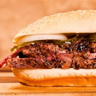 a beef sandwich with pickles and onions