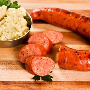 a sausage and potatoes on a cutting board