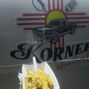 a hand holding a hot dog