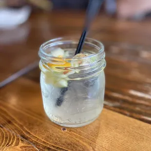 a glass of water with ice and a spoon