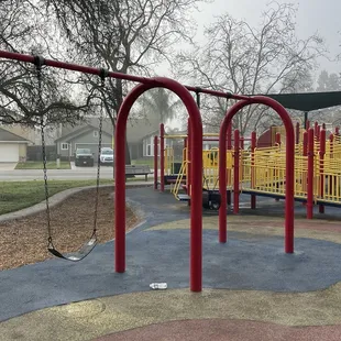 Toddler and regular swing. Big kid structure in background
