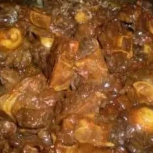 Every Friday slow cooked  Oxtails over rice with gravy, Served with a side of collard greens.