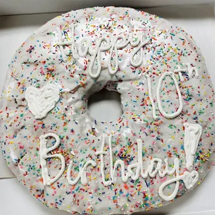 a white frosted donut with sprinkles