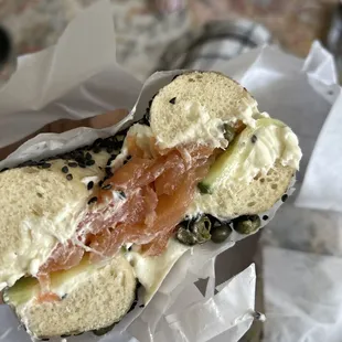 Black sesame bagel with lox, cucumbers, and capers