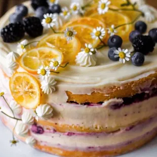 a cake with orange slices and blueberries