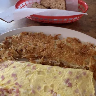 Ham and cheese omelette with crispy hash browns and wheat toast