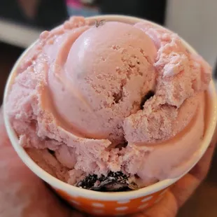 a hand holding a bowl of ice cream