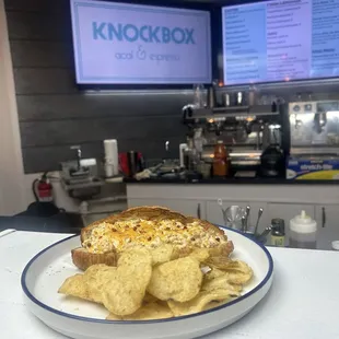 Egg Sando on a toasted warm, fluffy croissant and a side of chips