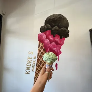 a hand holding an ice cream cone