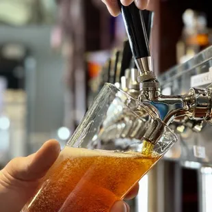a person pouring a beer