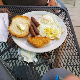 My husband&apos;s $15 Sunrise Breakfast--2 old eggs, 1 small piece of toast, 3 sausages, and 1 deep fried potato triangle