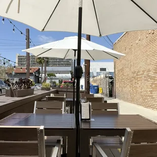 an outdoor dining area with tables and umbrellas