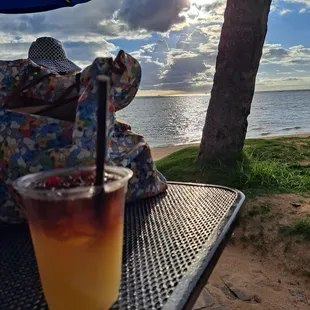 a drink on a table with a view of the ocean