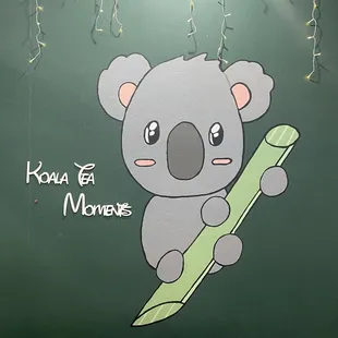a koala bear holding a green toothbrush