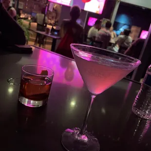 a cocktail in a martini glass on a bar