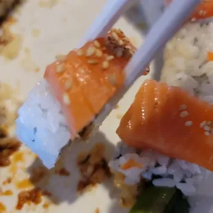 chopsticks holding a piece of sushi
