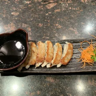 a plate of food and a bowl of dipping sauce