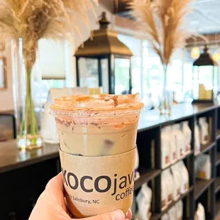 a hand holding a cup of coffee