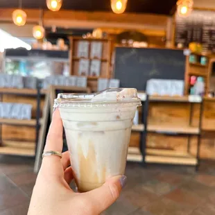 a hand holding a cup of iced coffee