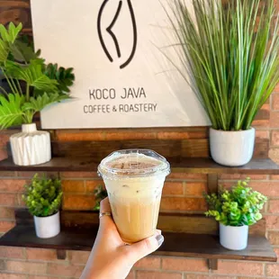 a hand holding a cup of coffee