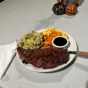 Ribeye steak, mashed potatoes, and macaroni and cheese.