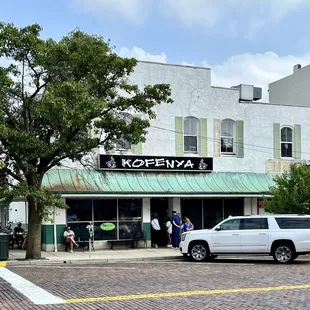 a white truck parked in front of a coffee shop