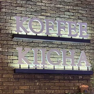 a brick wall with a sign that says koffee kiicha