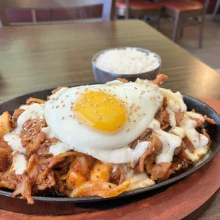 Spicy pork Daeji Bulgogi with added egg and added mozzarella and toppoki