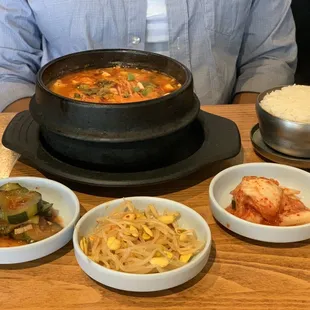 a man sitting at a table with bowls of food