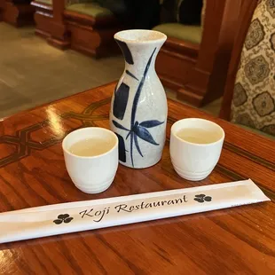 a pitcher and two cups on a table