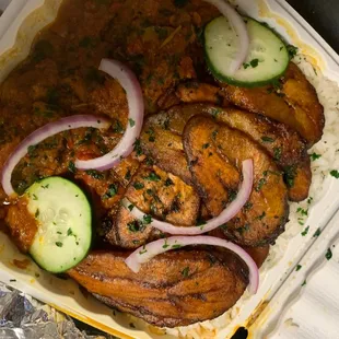 a chicken dish with onions and cucumbers