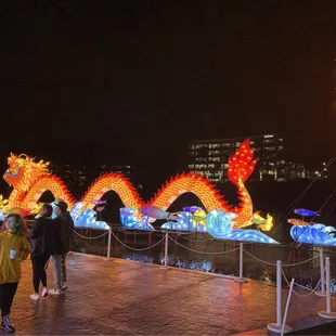 two people walking past a dragon sculpture