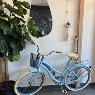 a blue bicycle parked against a white wall