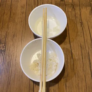 two bowls of rice and chopsticks