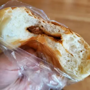 a half eaten sandwich wrapped in plastic