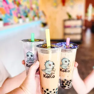 a person holding two cups of boba tea