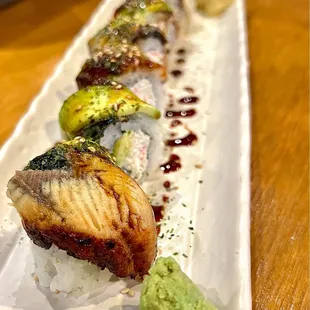 Dragon Roll. Good eel and avocado portions on top; the inside is filled with imitation crab. Eel sauce drizzled on top for added sweetness.
