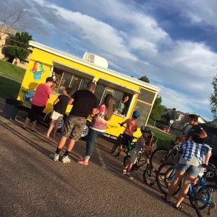a group of people standing in front of a food truck