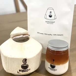 a jar of honey next to a bag of kokonut